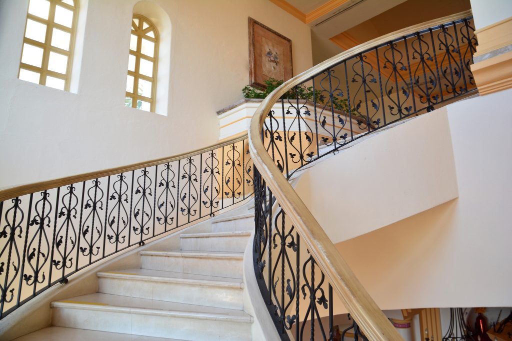Interior iron railing along a curved staircase