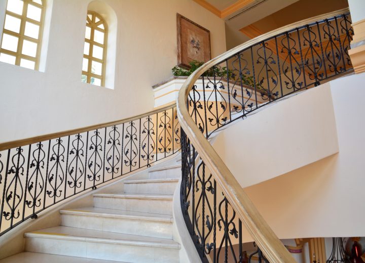 Interior iron railing along a curved staircase