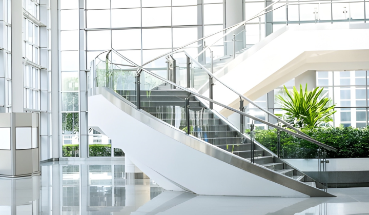 Glass and stainless steel railing on a bright atrium staircase