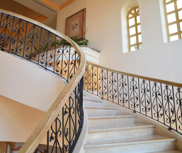 Wrought iron staircase railing in an arched hall